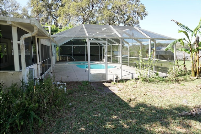 outdoor pool with glass enclosure and a patio