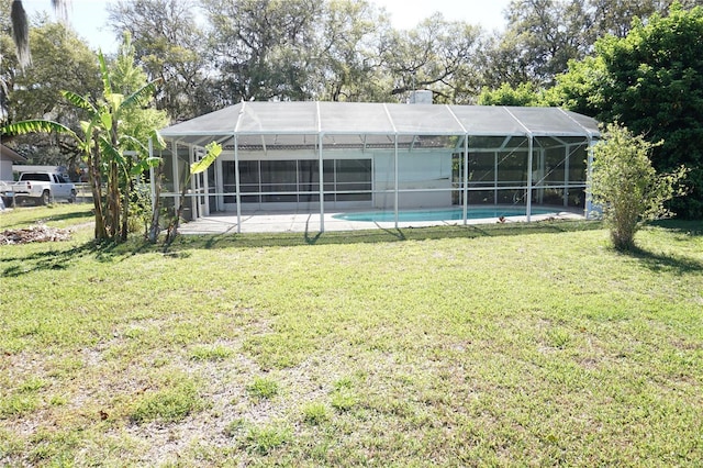 back of house featuring a lanai, a yard, an outdoor pool, and a patio