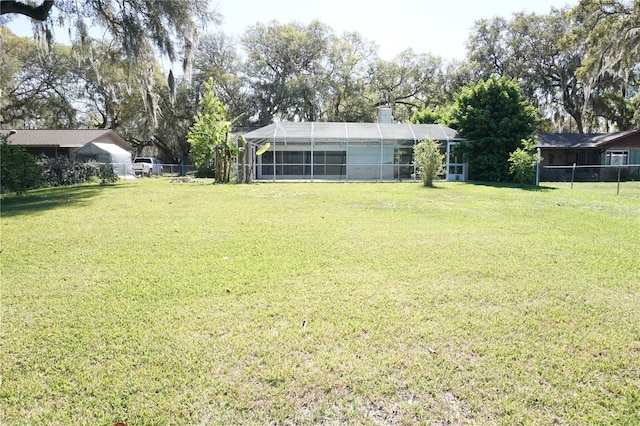 view of yard featuring a lanai and fence