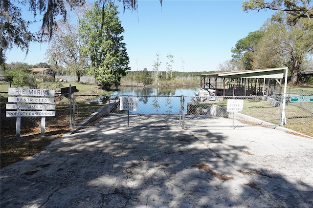 dock area with a gate, fence, and a water view