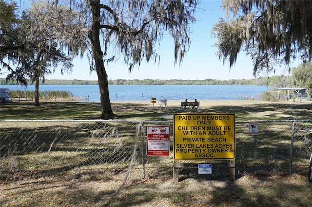 view of property's community featuring a water view and fence