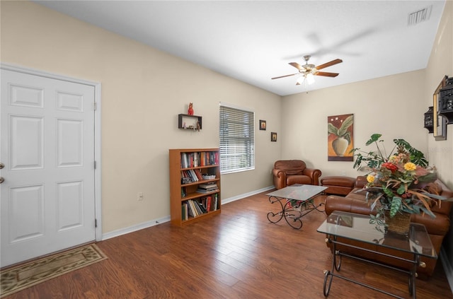 living room with a ceiling fan, wood finished floors, visible vents, and baseboards