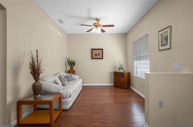 living area with a ceiling fan, wood finished floors, visible vents, and baseboards