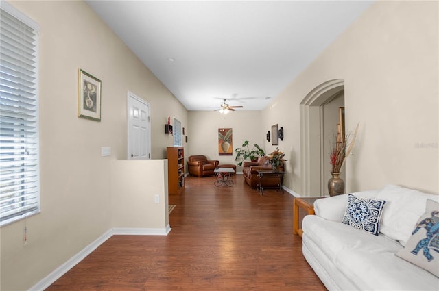 living room featuring baseboards, wood finished floors, and a ceiling fan