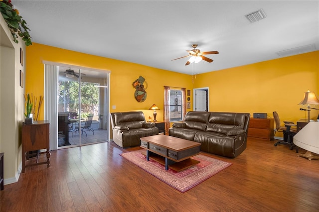 living area with baseboards, wood finished floors, visible vents, and ceiling fan