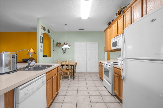 kitchen featuring a sink, white appliances, light tile patterned floors, and light countertops