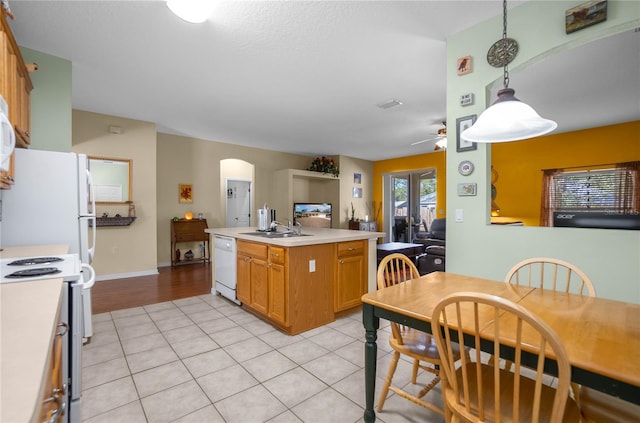 kitchen with dishwasher, light countertops, arched walkways, electric range, and a sink