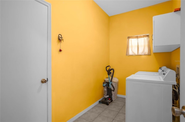 laundry area featuring light tile patterned floors, baseboards, and washer and clothes dryer