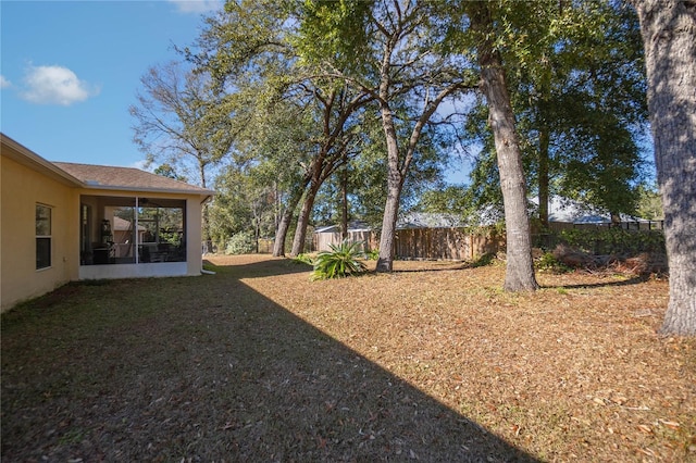 view of yard with a fenced backyard and a sunroom