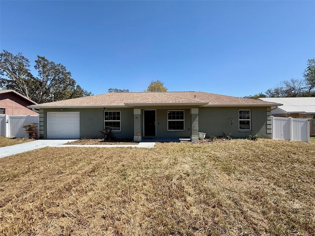 ranch-style house with stucco siding, a garage, a front yard, and fence