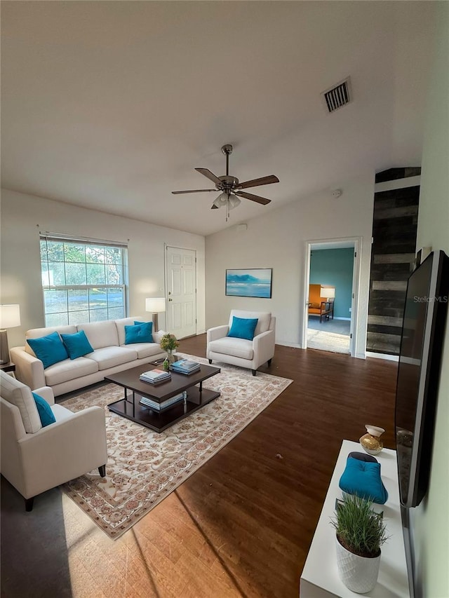 living area with a ceiling fan, lofted ceiling, wood finished floors, and visible vents