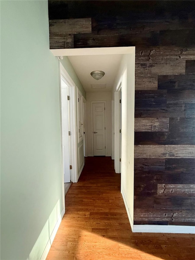 hall featuring light wood-style flooring and baseboards