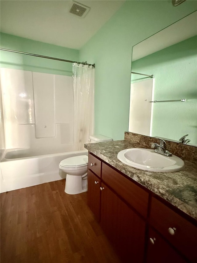 full bath featuring vanity, wood finished floors, visible vents, shower / tub combo, and toilet