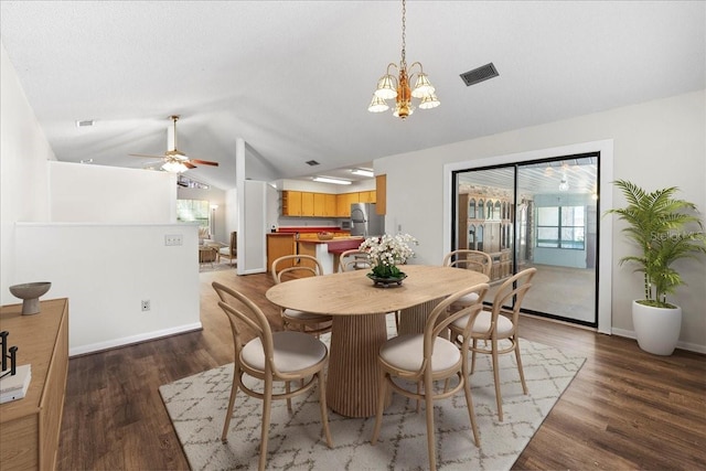 dining space featuring visible vents, ceiling fan with notable chandelier, wood finished floors, baseboards, and lofted ceiling