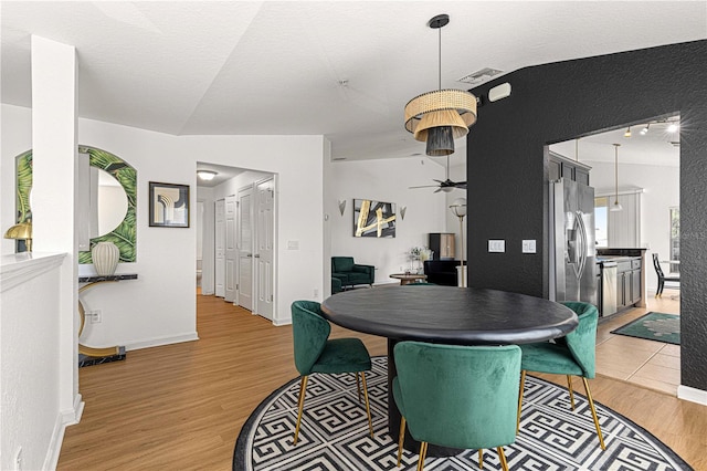 dining area with light wood-style flooring, baseboards, and ceiling fan