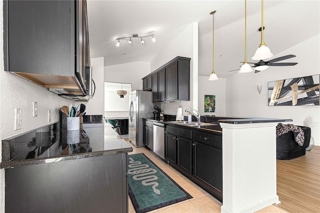 kitchen with light tile patterned flooring, ceiling fan, a sink, vaulted ceiling, and appliances with stainless steel finishes