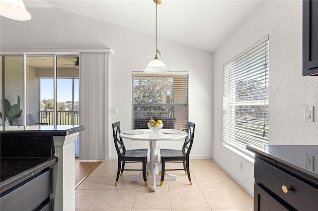 dining space with a wealth of natural light, light tile patterned floors, and vaulted ceiling