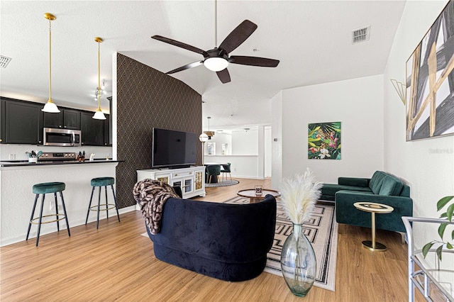 living area with light wood-type flooring, visible vents, and ceiling fan