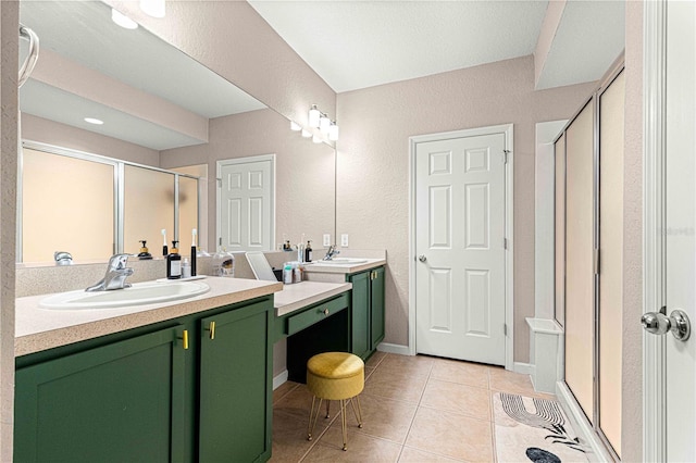 full bath featuring a sink, two vanities, a shower stall, and tile patterned flooring