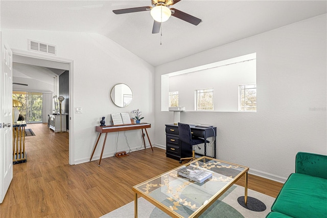 office space featuring visible vents, wood finished floors, baseboards, ceiling fan, and vaulted ceiling