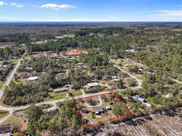 birds eye view of property featuring a view of trees