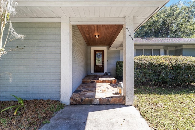 view of exterior entry featuring brick siding