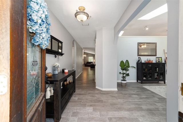 entryway featuring baseboards, arched walkways, visible vents, and wood tiled floor