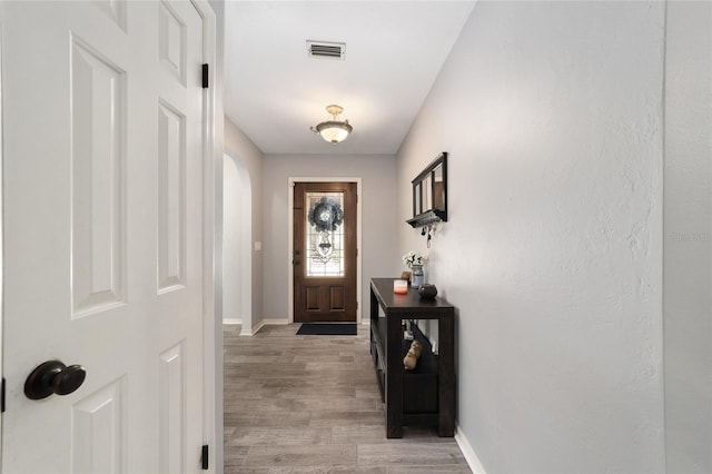 doorway featuring visible vents, baseboards, and light wood-style floors