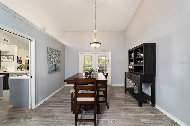 dining room with visible vents, wood finished floors, french doors, baseboards, and vaulted ceiling