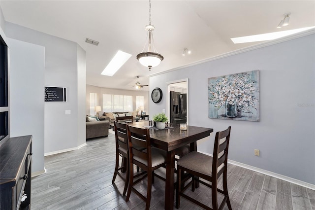 dining space featuring wood finished floors, visible vents, and baseboards