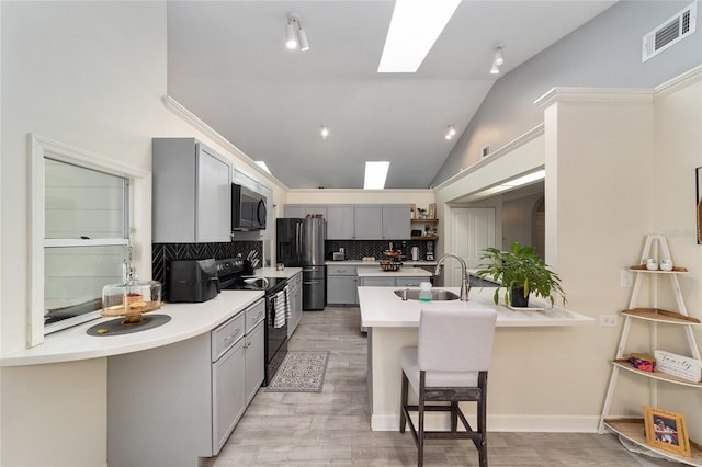 kitchen with electric range, visible vents, gray cabinetry, a sink, and stainless steel fridge