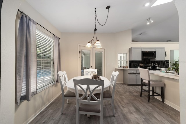 dining space with dark wood-type flooring, french doors, and baseboards