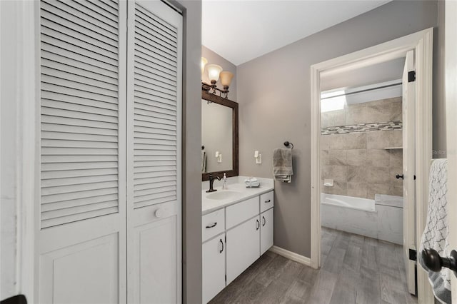 bathroom featuring a bathing tub, wood finished floors, a closet, baseboards, and vanity