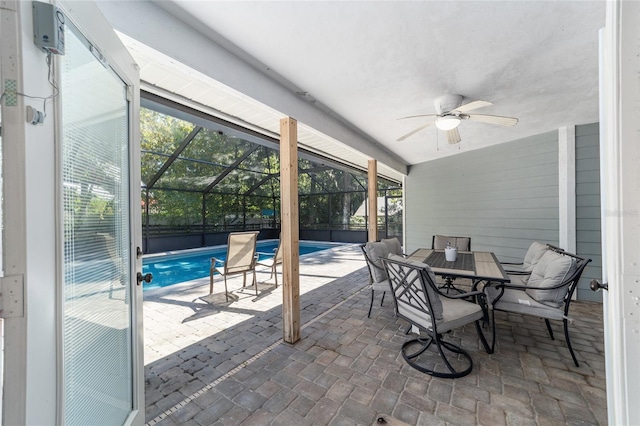 view of patio / terrace featuring glass enclosure, outdoor dining area, a ceiling fan, and a fenced in pool