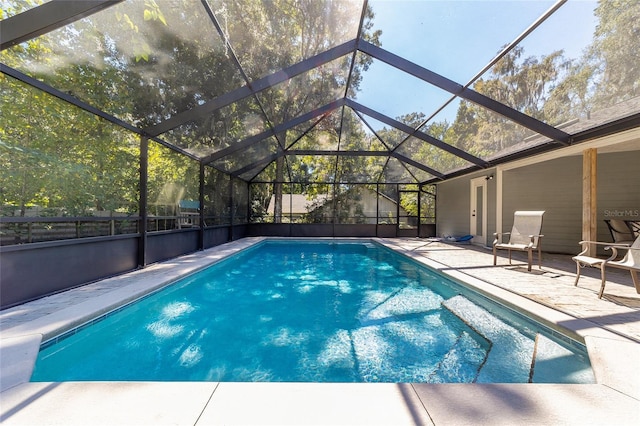 view of pool with glass enclosure, a patio area, and a fenced in pool