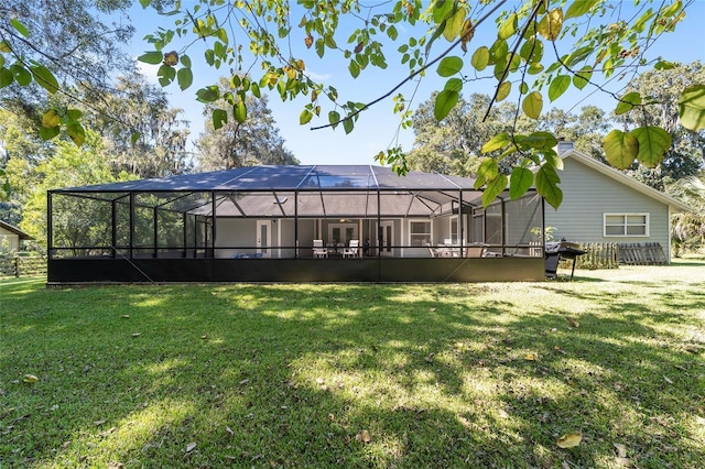 back of house with a yard and a lanai