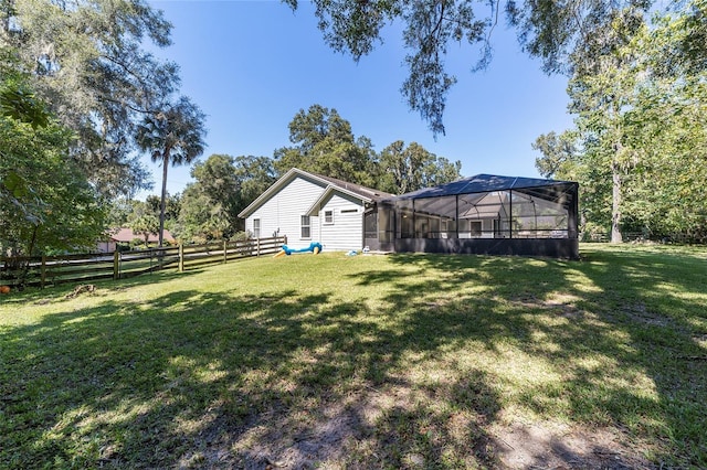 view of yard featuring glass enclosure and a fenced backyard