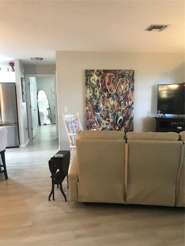 living room with light wood finished floors and visible vents