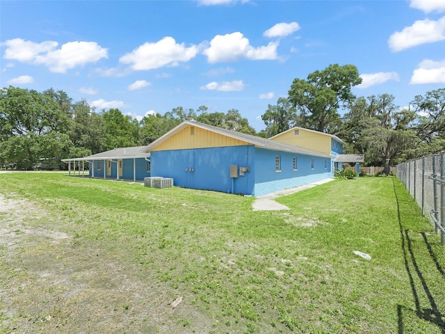 back of property featuring a yard, fence, and cooling unit