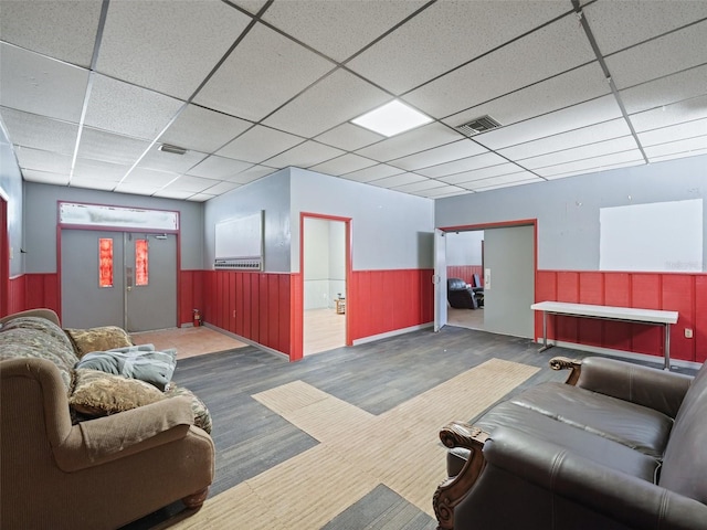 interior space featuring visible vents, a drop ceiling, and wainscoting