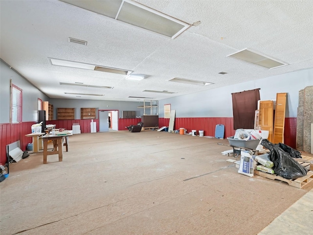 misc room featuring a wainscoted wall, a textured ceiling, and visible vents