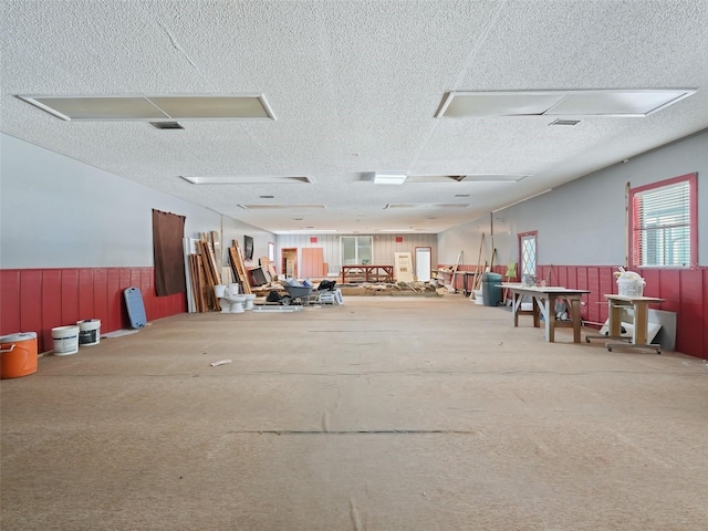 miscellaneous room featuring visible vents, a textured ceiling, wainscoting, and carpet