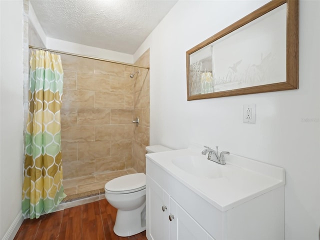 full bath with toilet, wood finished floors, vanity, and a tile shower