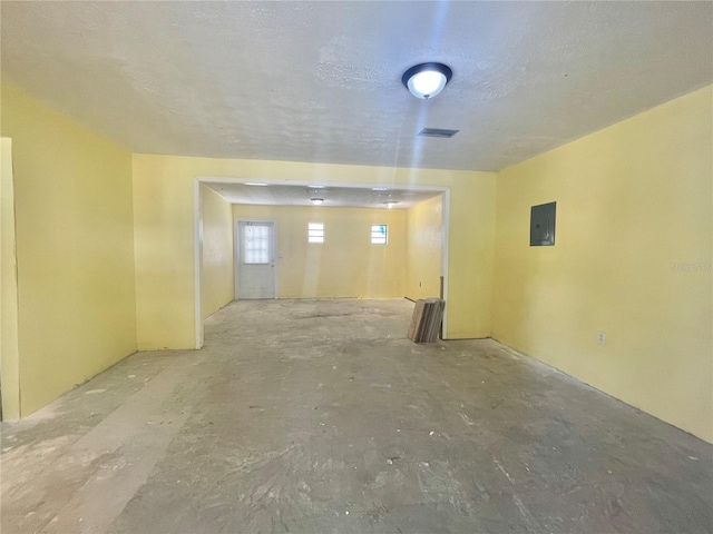 unfurnished room with electric panel, visible vents, and a textured ceiling