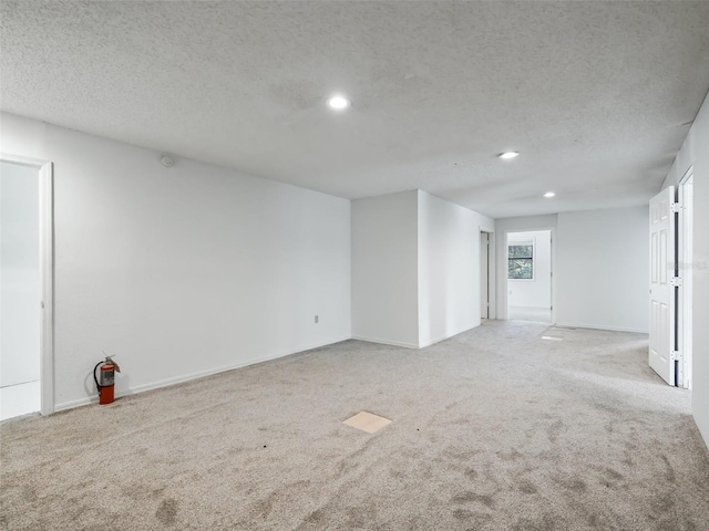 empty room with carpet flooring, recessed lighting, and a textured ceiling