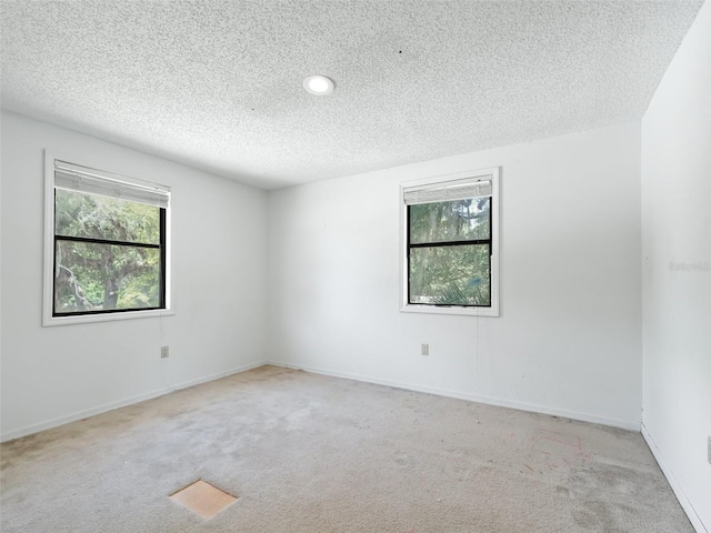 carpeted empty room featuring baseboards and a textured ceiling