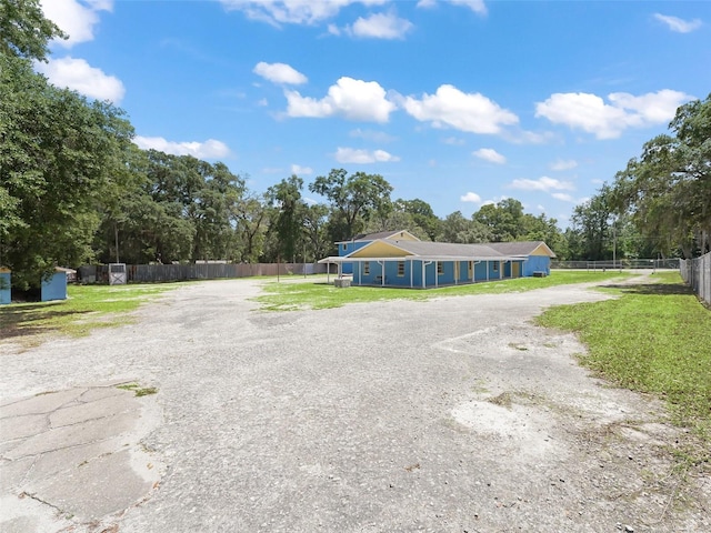 view of front facade featuring gravel driveway and fence