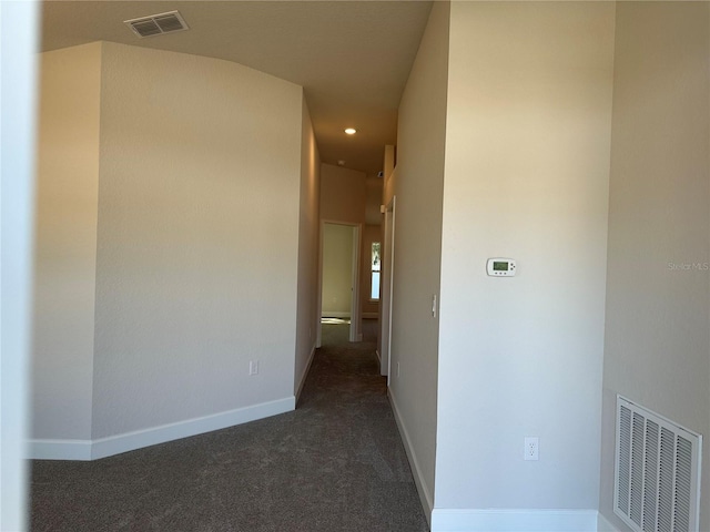 hallway featuring recessed lighting, visible vents, dark carpet, and baseboards