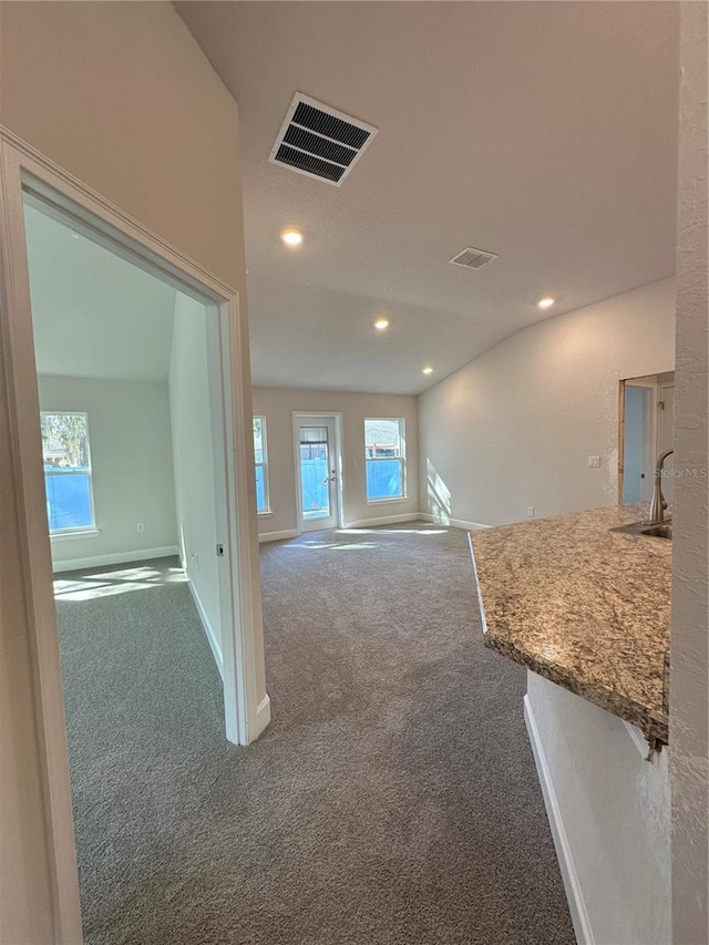 carpeted empty room featuring recessed lighting, baseboards, visible vents, and a sink