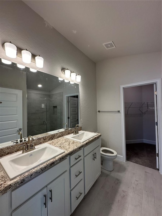 full bath with a sink, visible vents, double vanity, and a shower stall